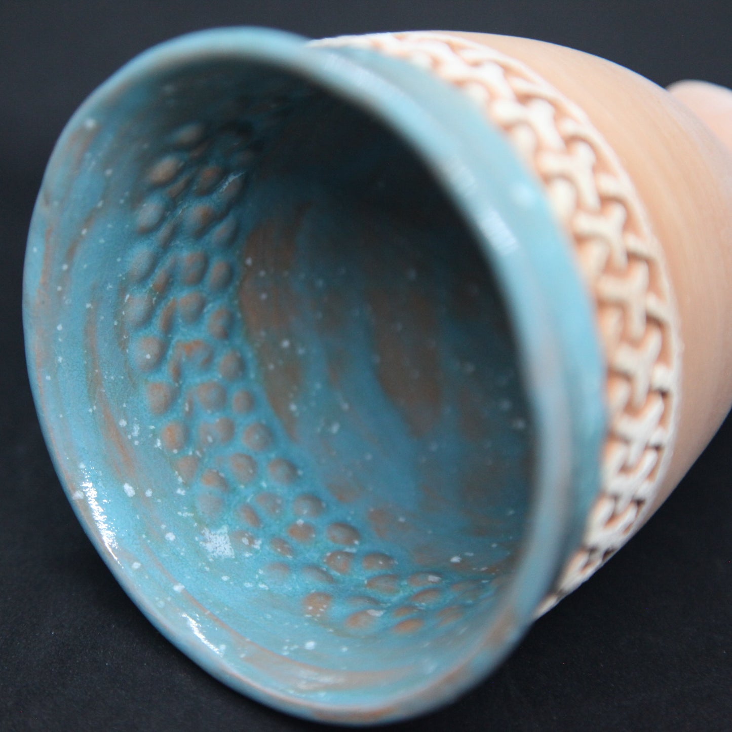 Gobelet bleu turquoise sur terre rouge - motif de maillage