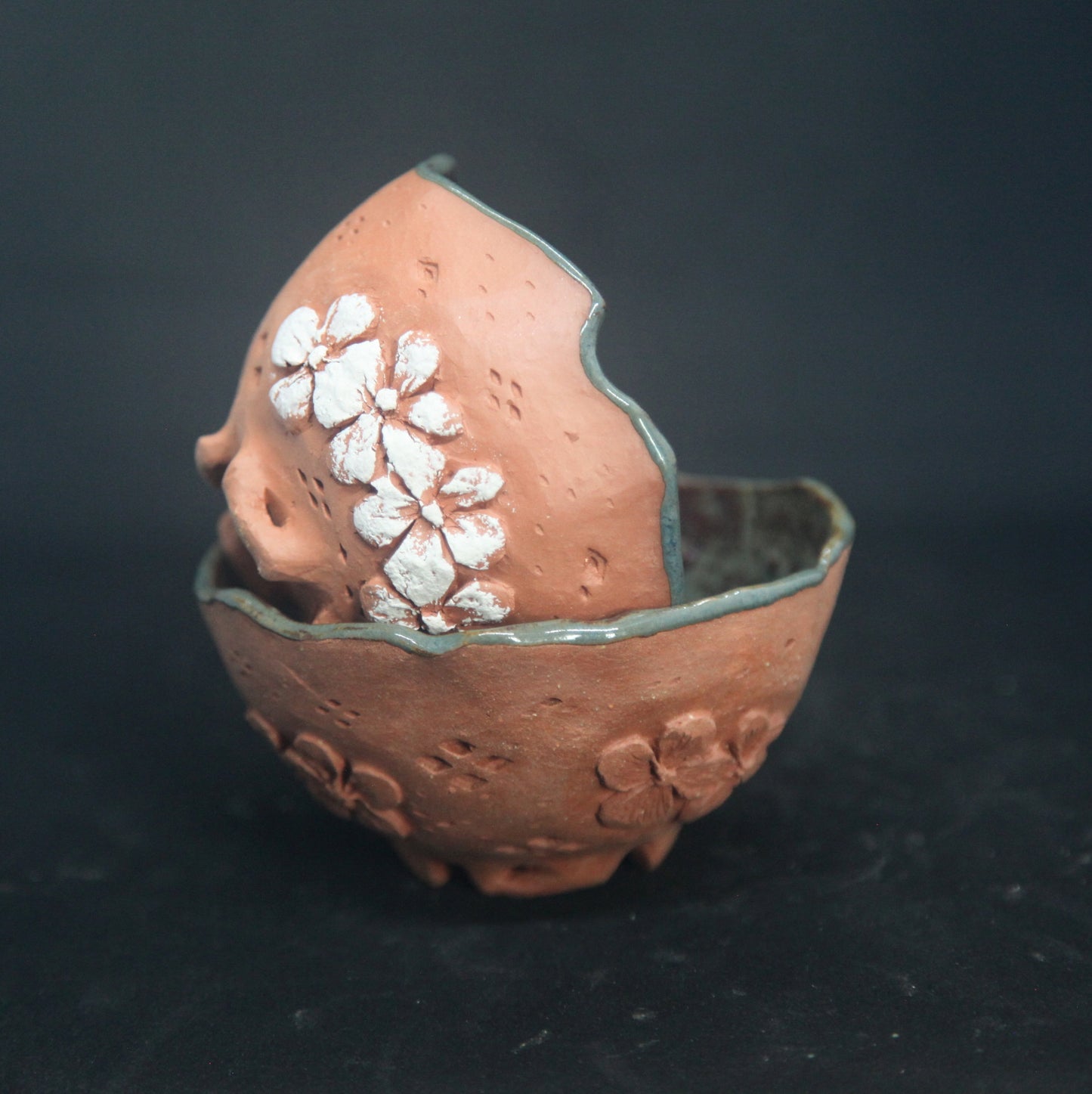 Tasses vert foncé sur terre rouge - motifs de fleurs