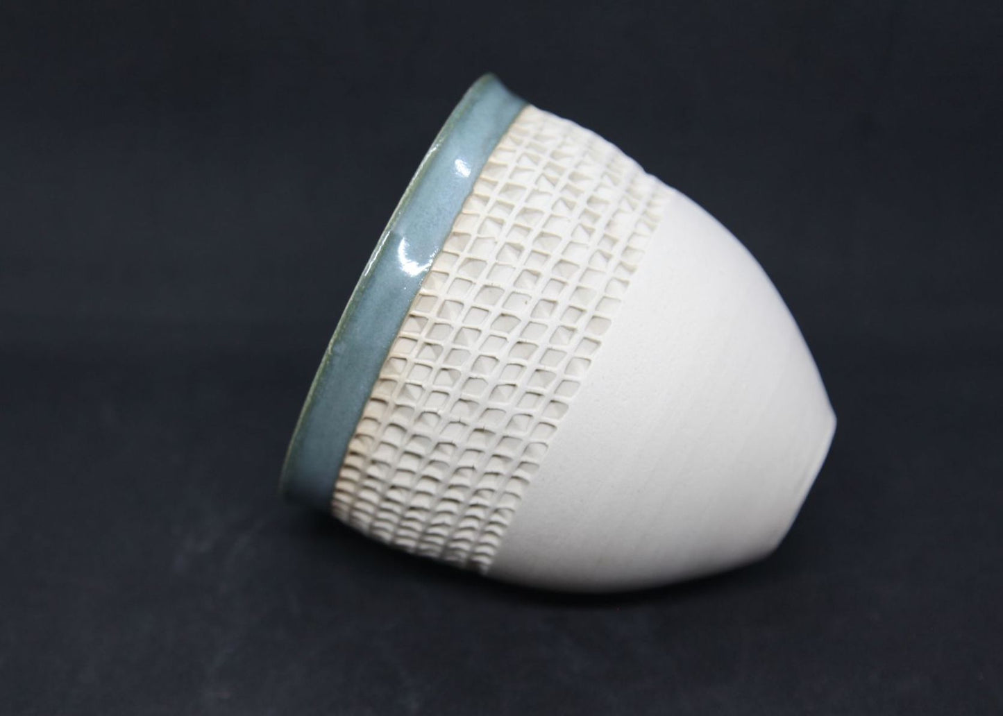 Green bowl on white clay, twisted pattern