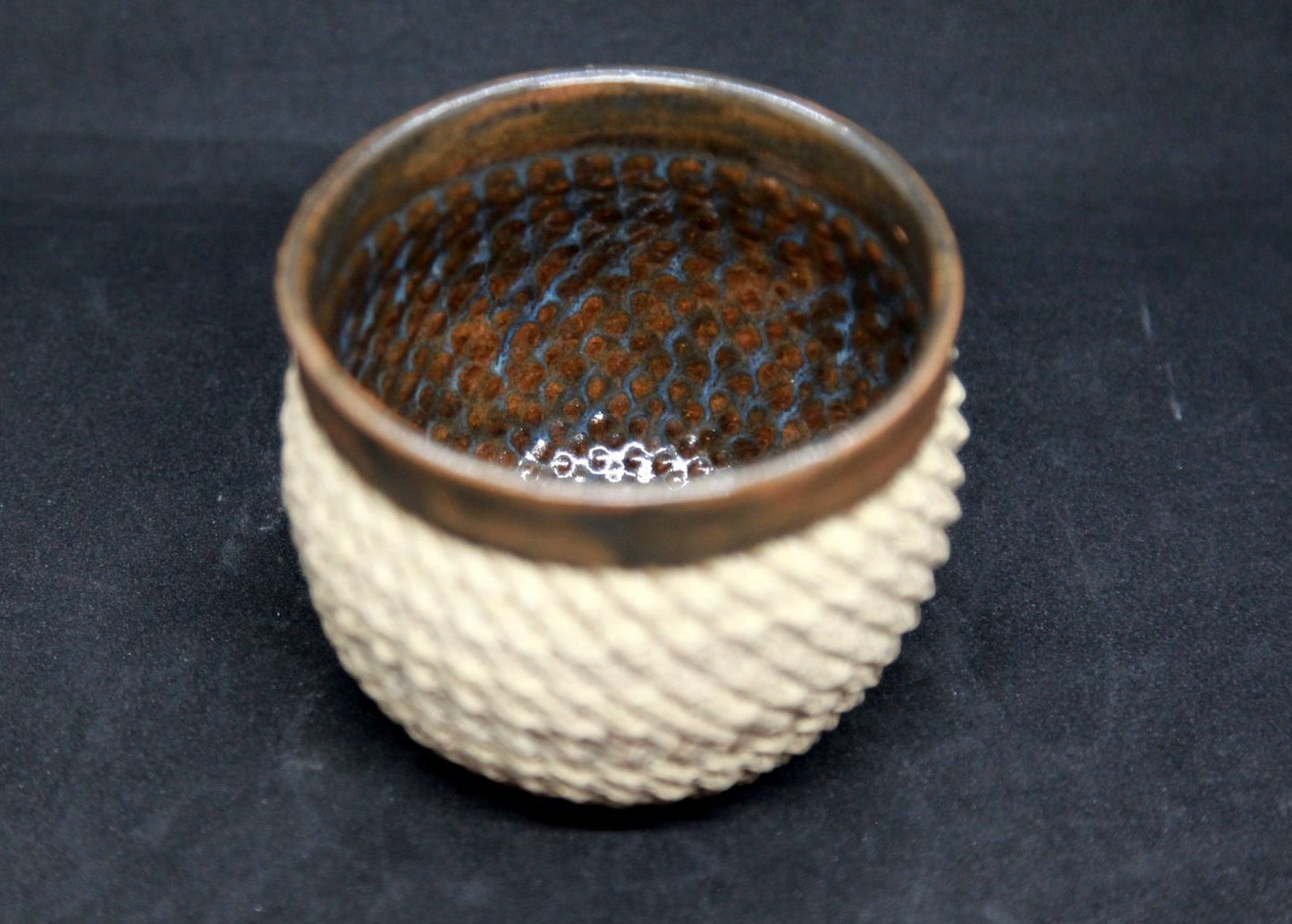 Brown and blue bowl on beige clay - braiding pattern