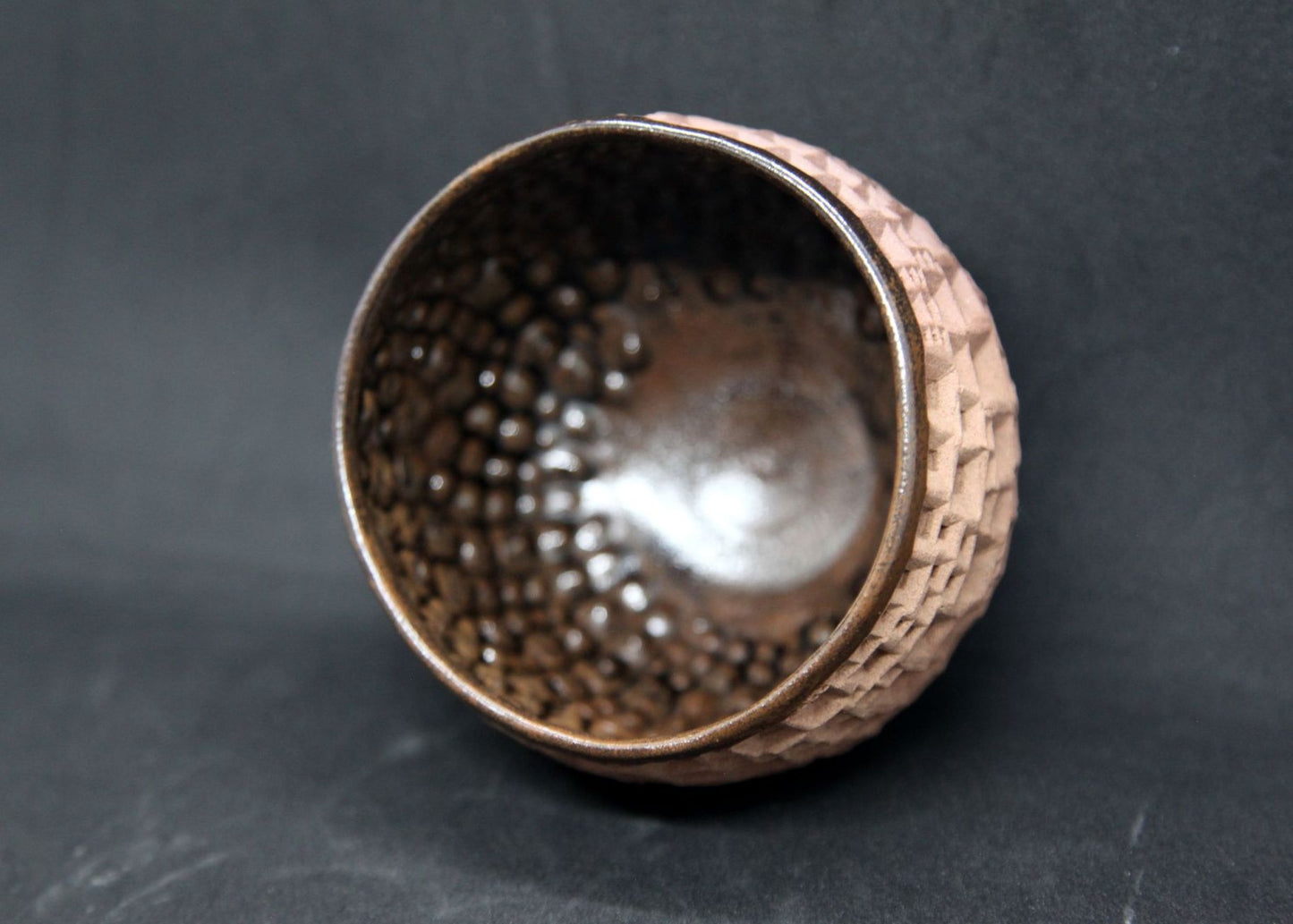 Iron tenmoku bowl on buff clay