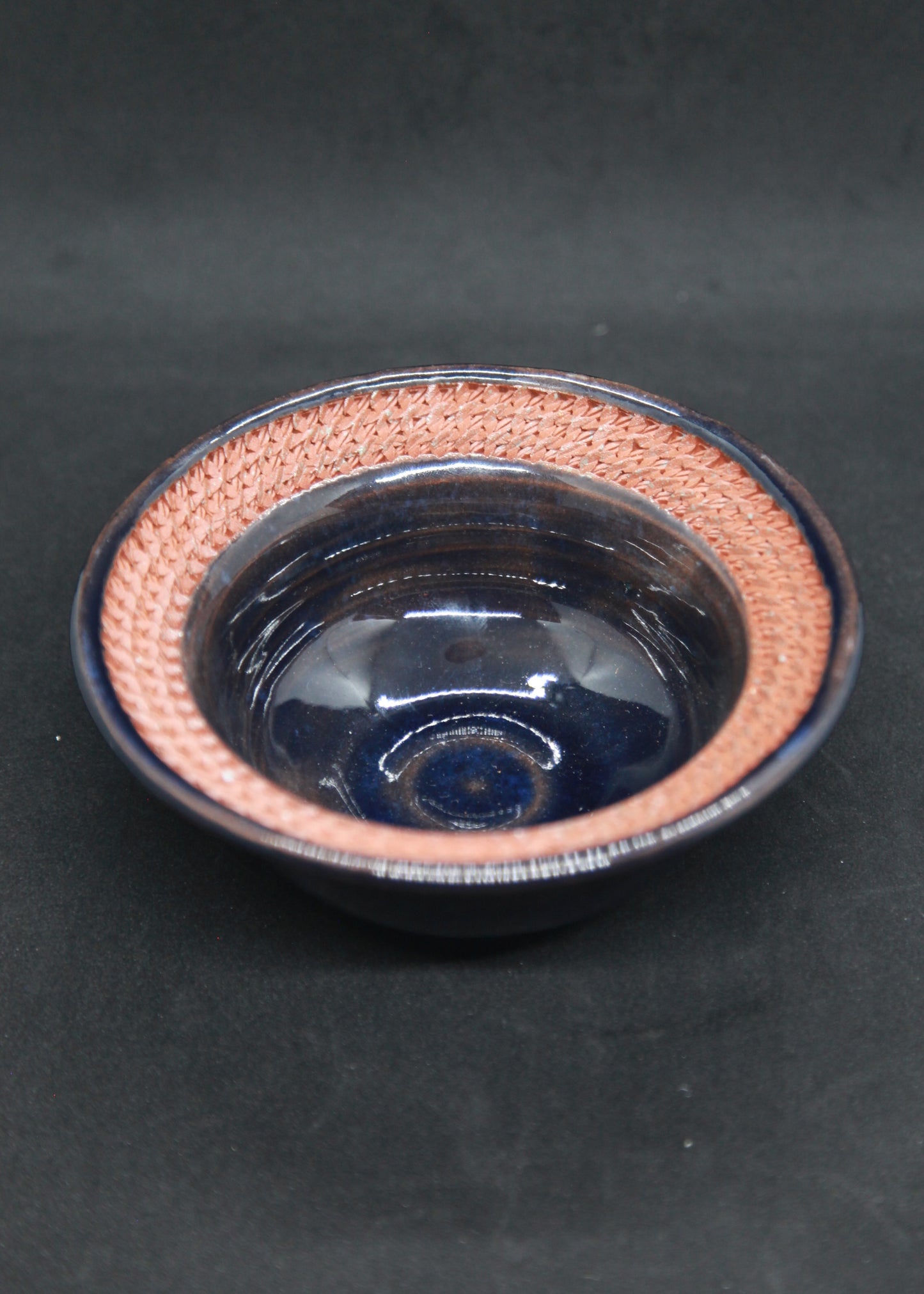Dark blue marli bowl on red glaze - braiding pattern