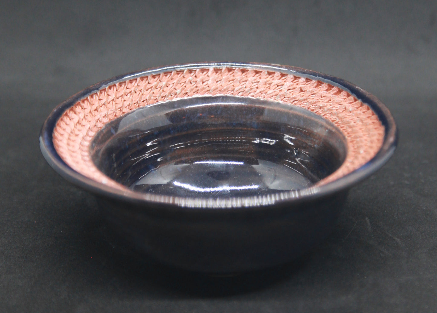 Dark blue marli bowl on red glaze - braiding pattern