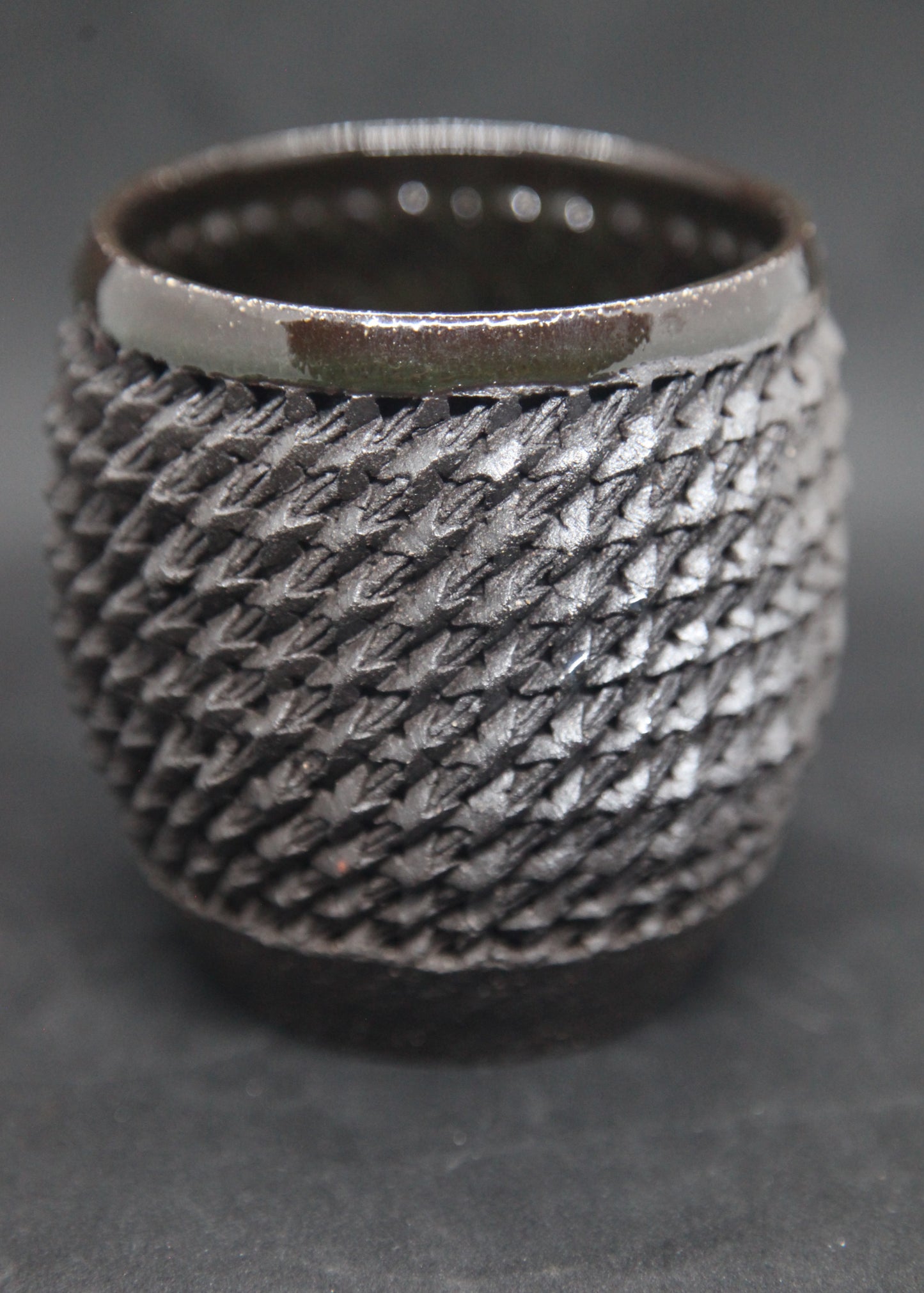Black mug on black clay - braiding pattern