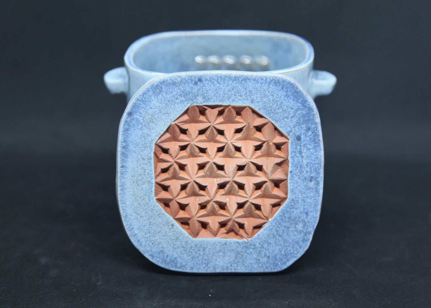 Blue tea box on red clay - origami pattern