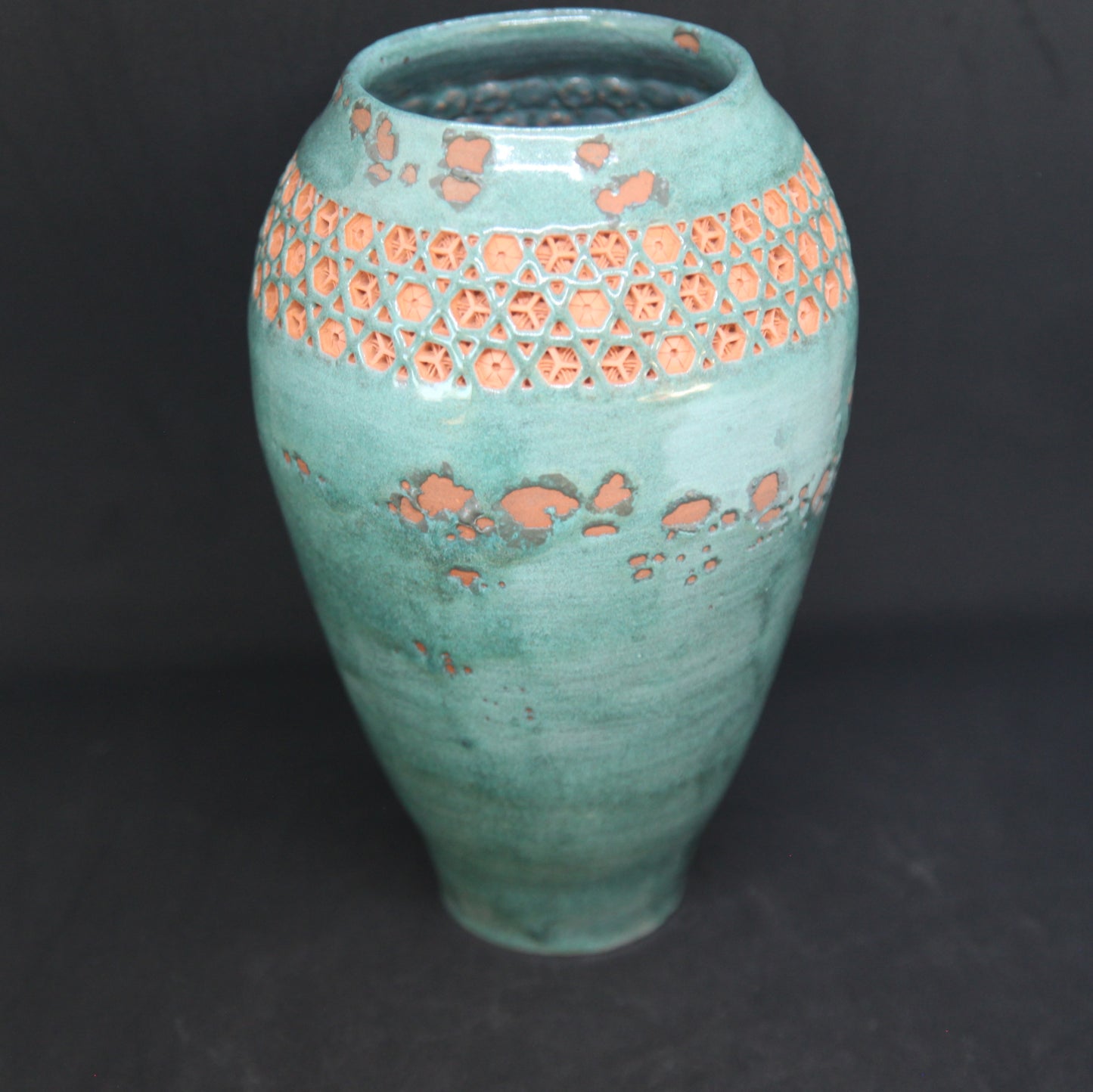 Green vase on red clay - origami pattern