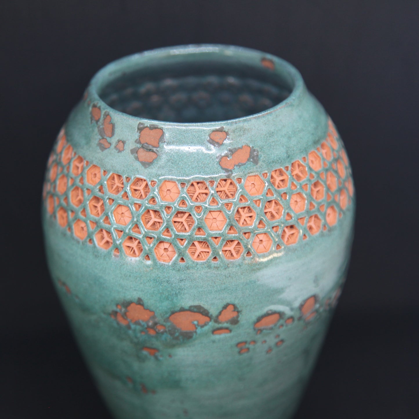 Green vase on red clay - origami pattern