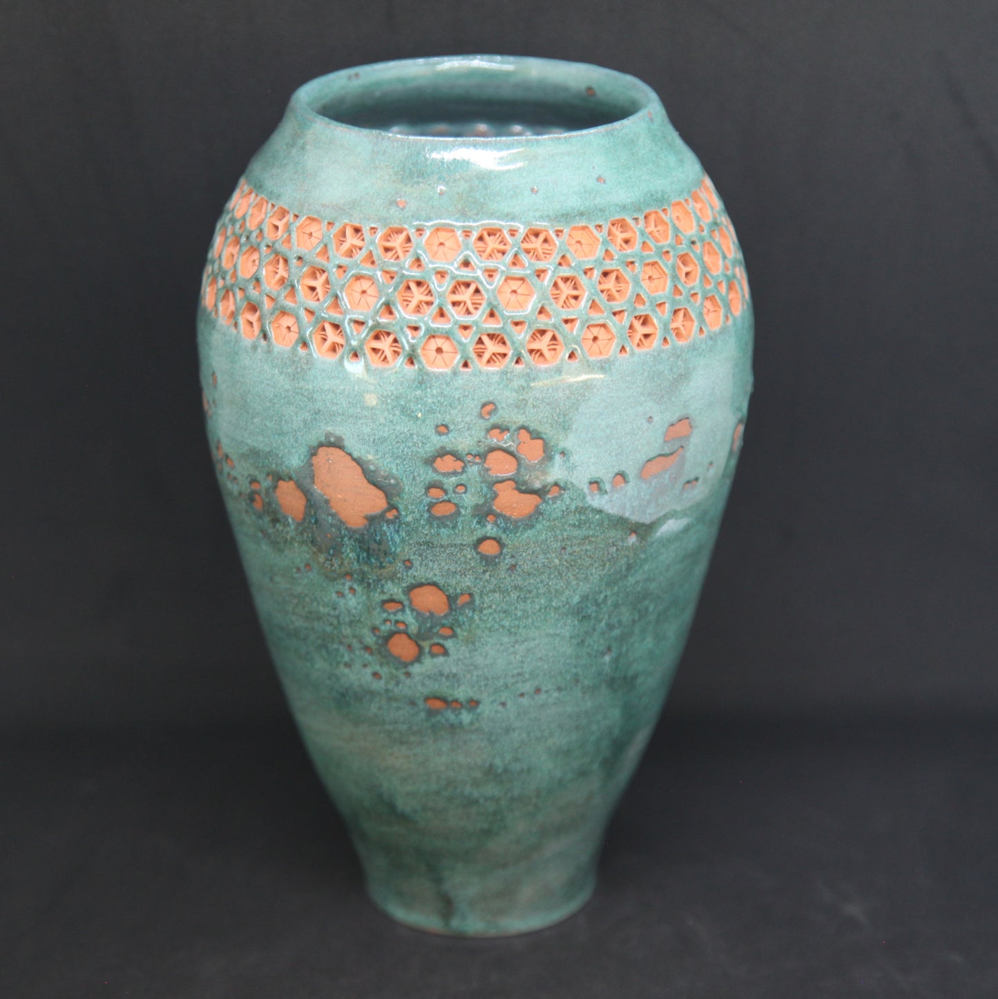 Green vase on red clay - origami pattern