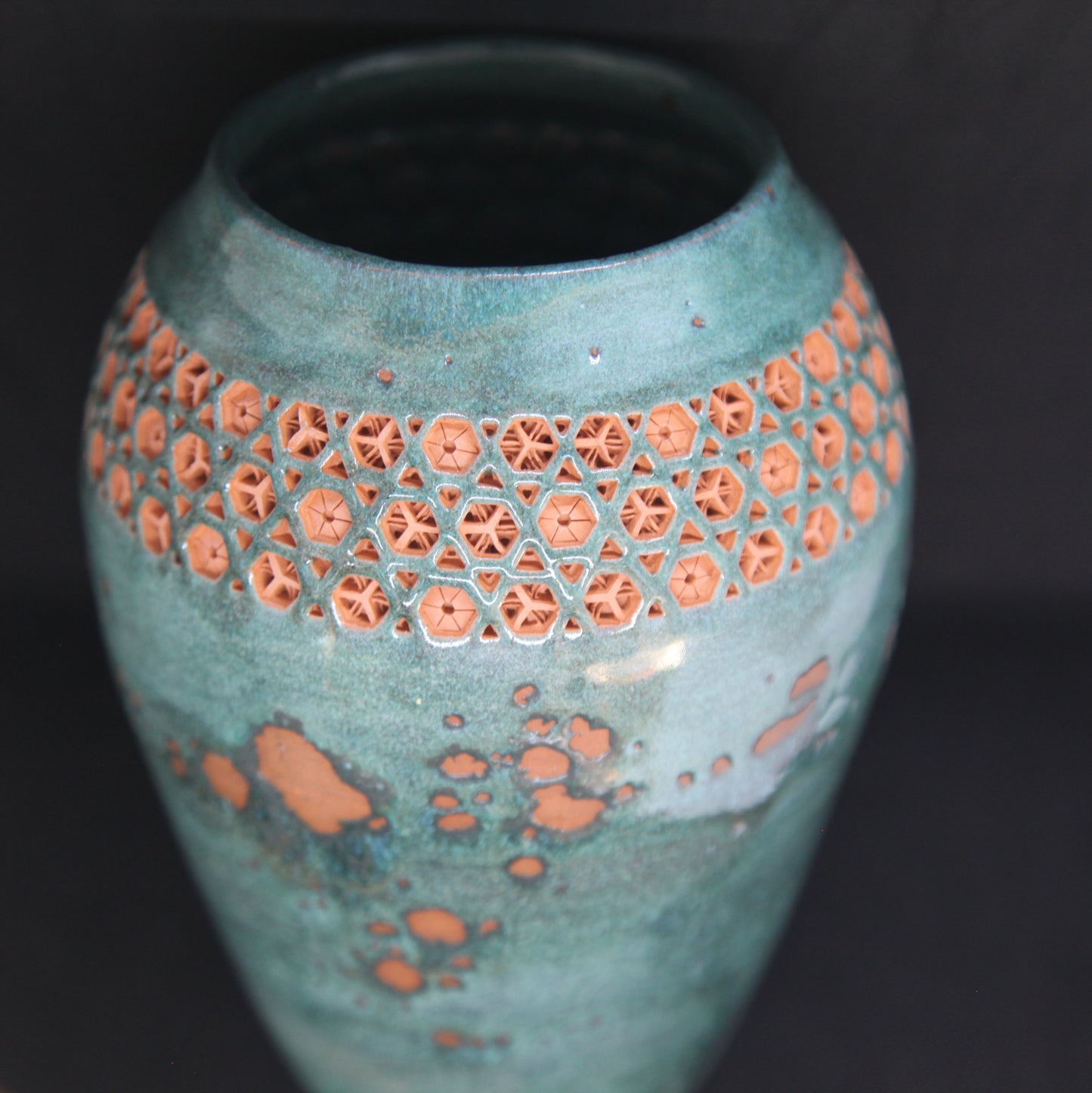 Green vase on red clay - origami pattern