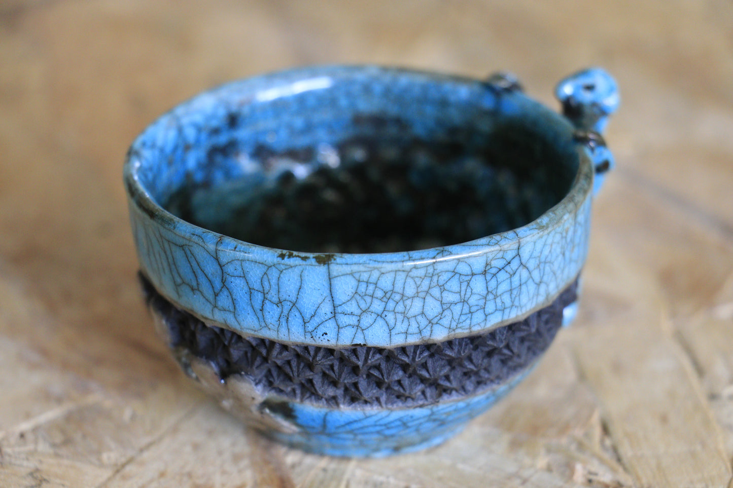 Tasse raku turquoise et noire, avec personnage