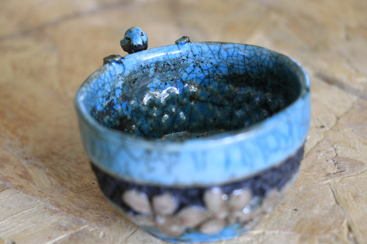 Tasse raku turquoise et noire, avec personnage