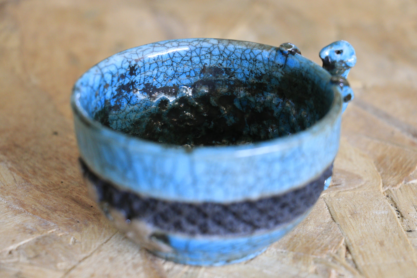 Tasse raku turquoise et noire, avec personnage