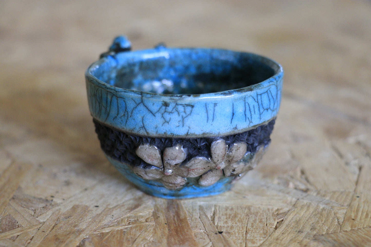 Tasse raku turquoise et noire, avec personnage