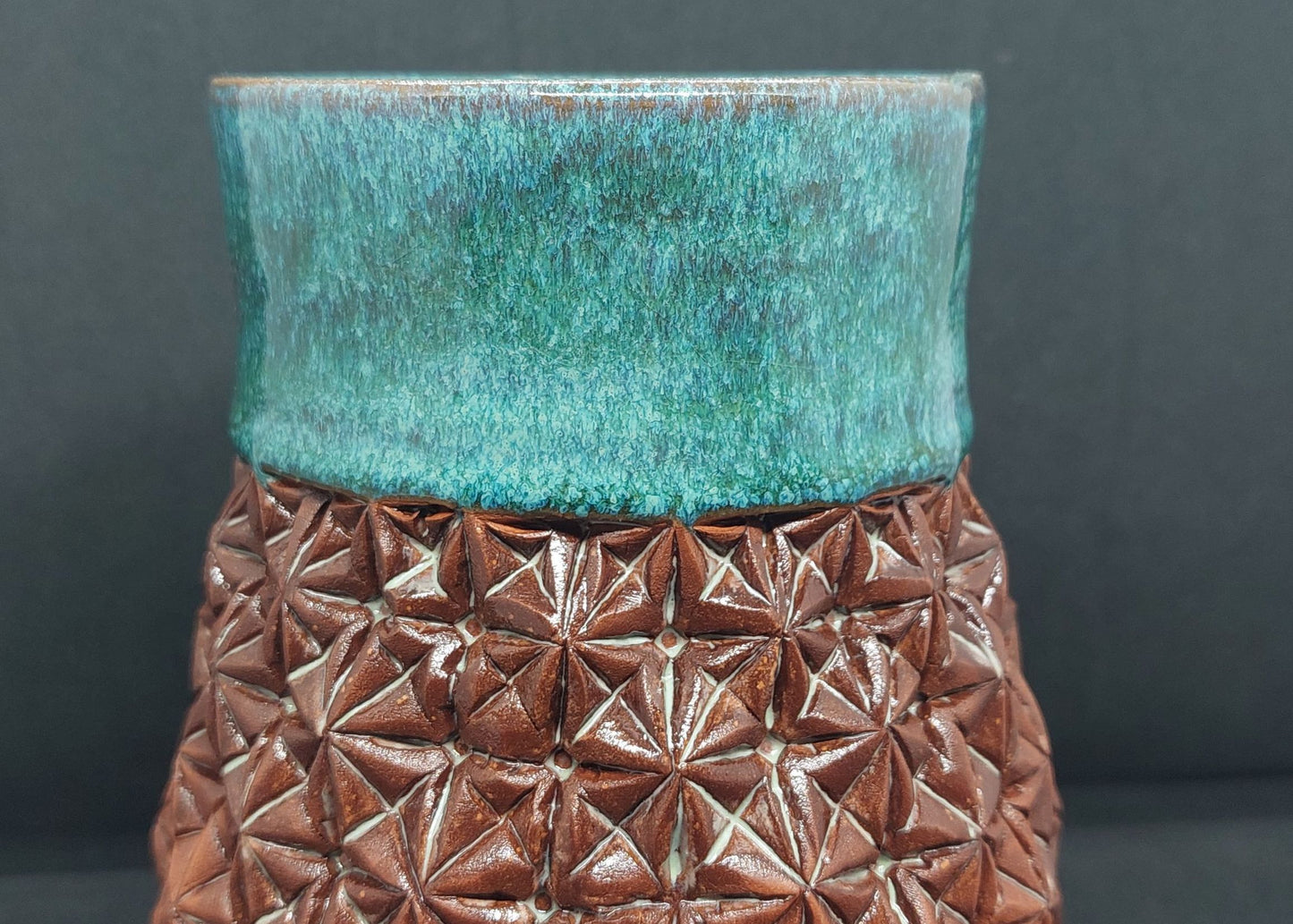 Green vase on red clay - origami pattern