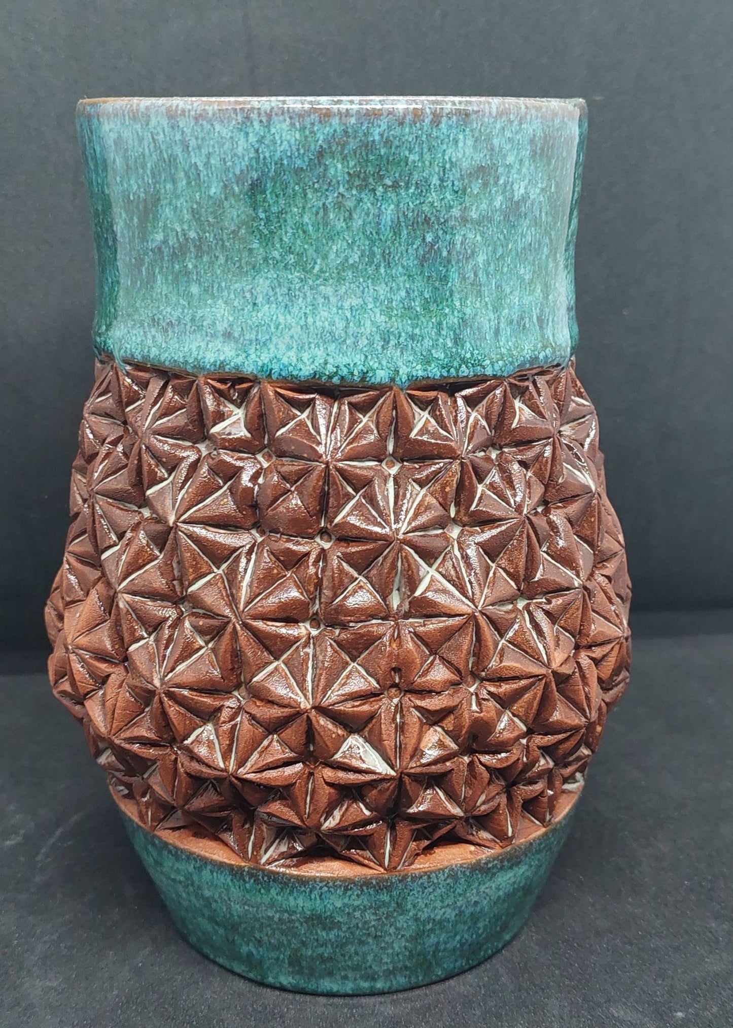 Green vase on red clay - origami pattern