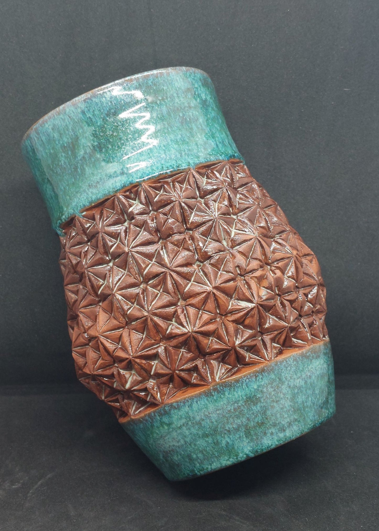 Vase vert sur terre rouge - motif origami