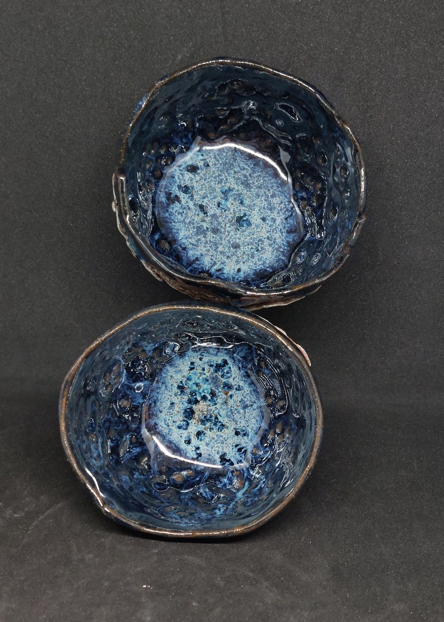 Blue cups on black and red clays - flower patterns
