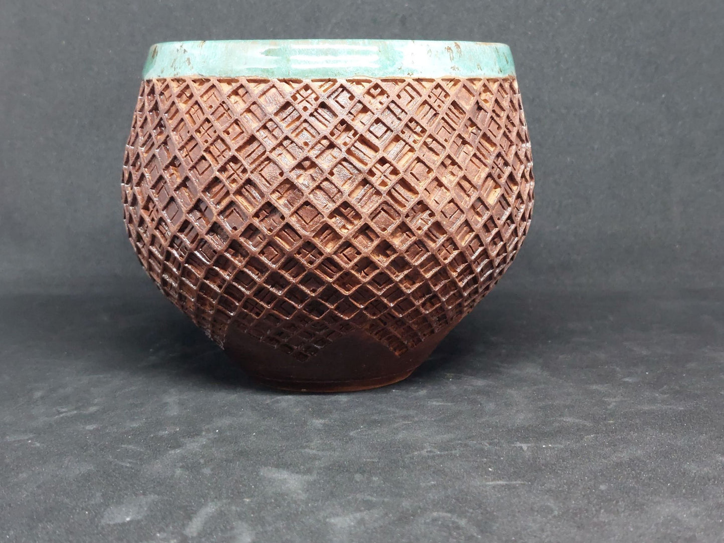 Green bowl on red clay - tartan pattern