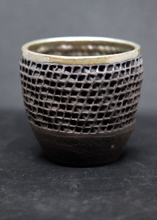 Green mug on black clay - twisted pattern