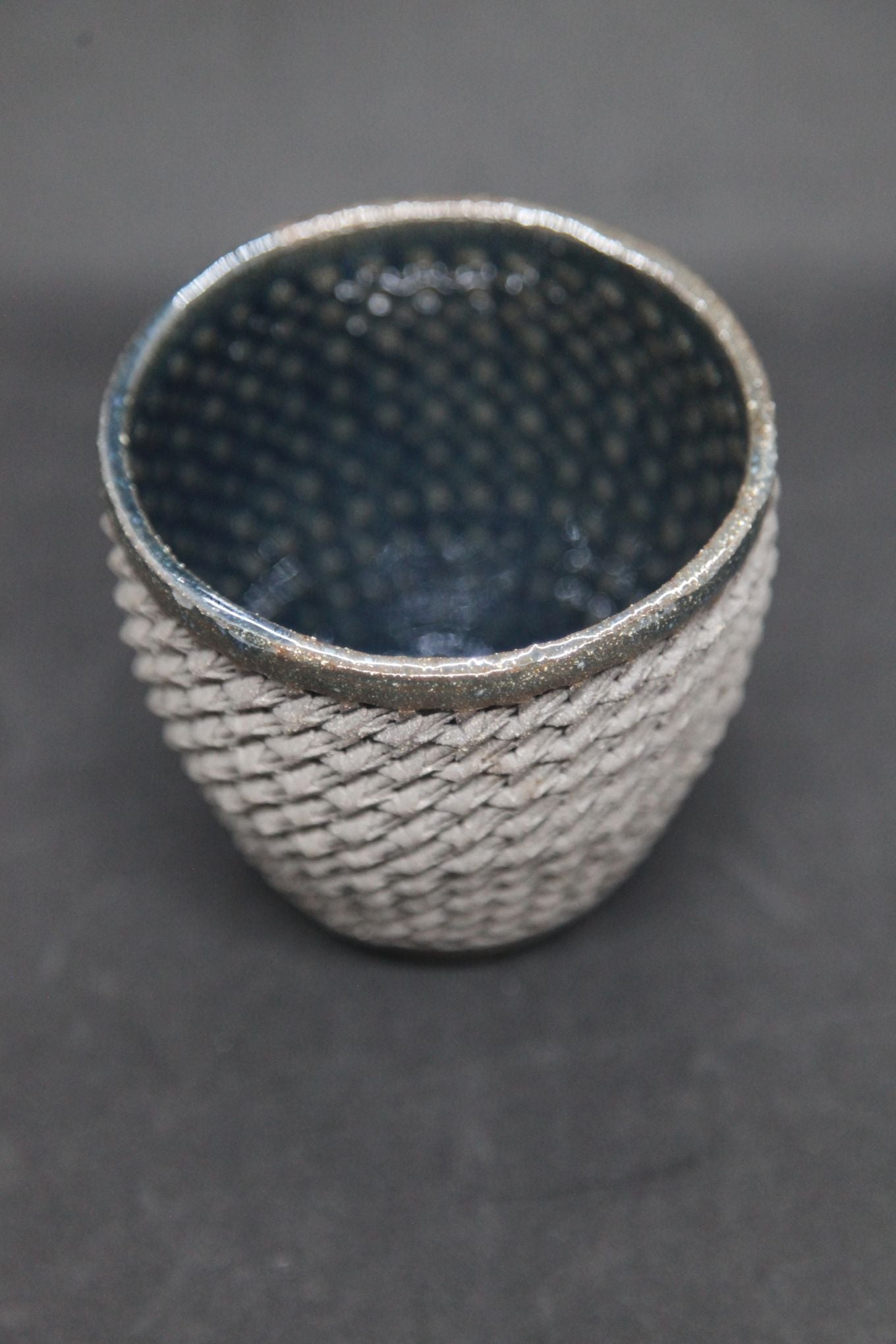Blue mug on gray clay - braiding pattern