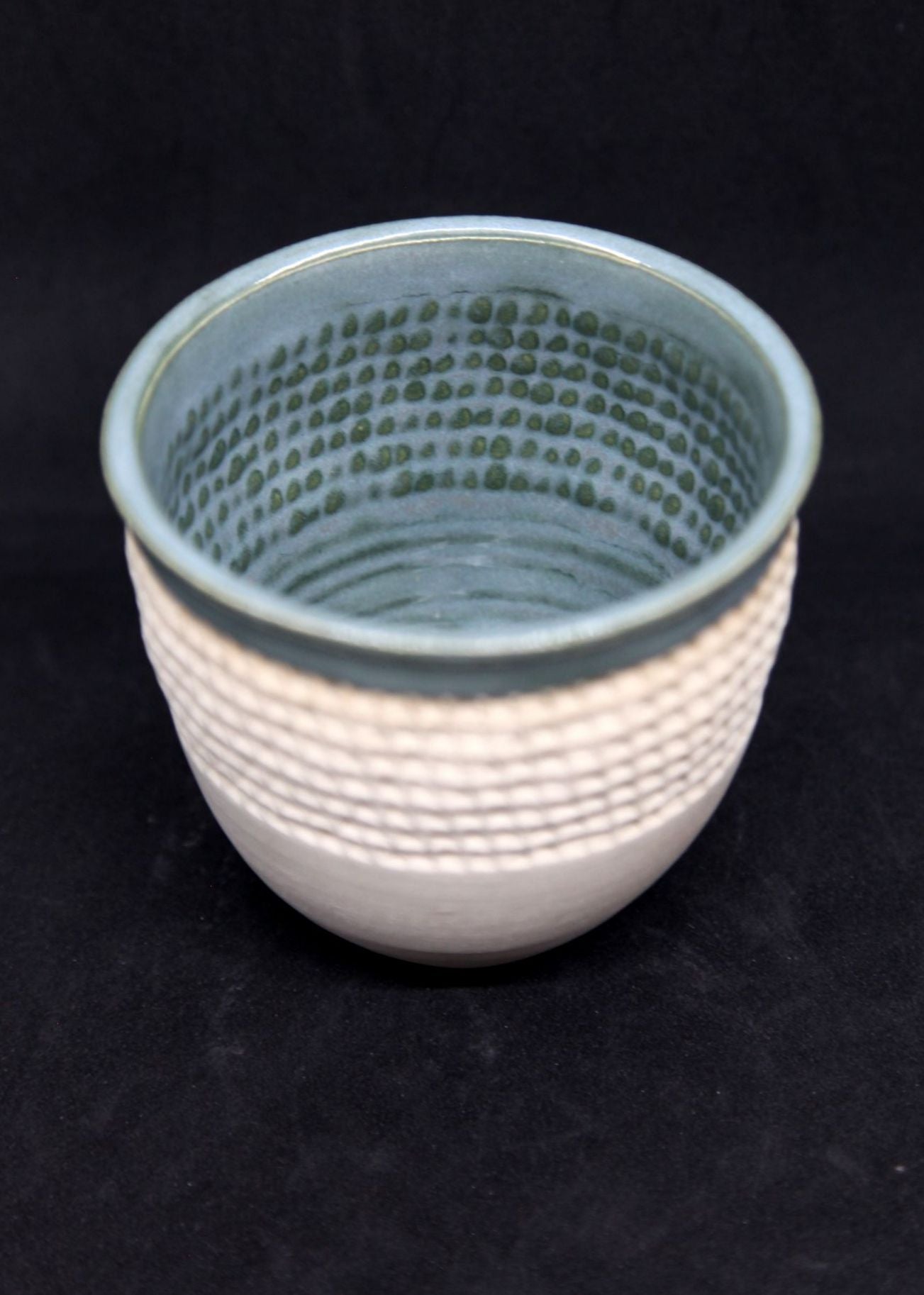 Green bowl on white clay, twisted pattern