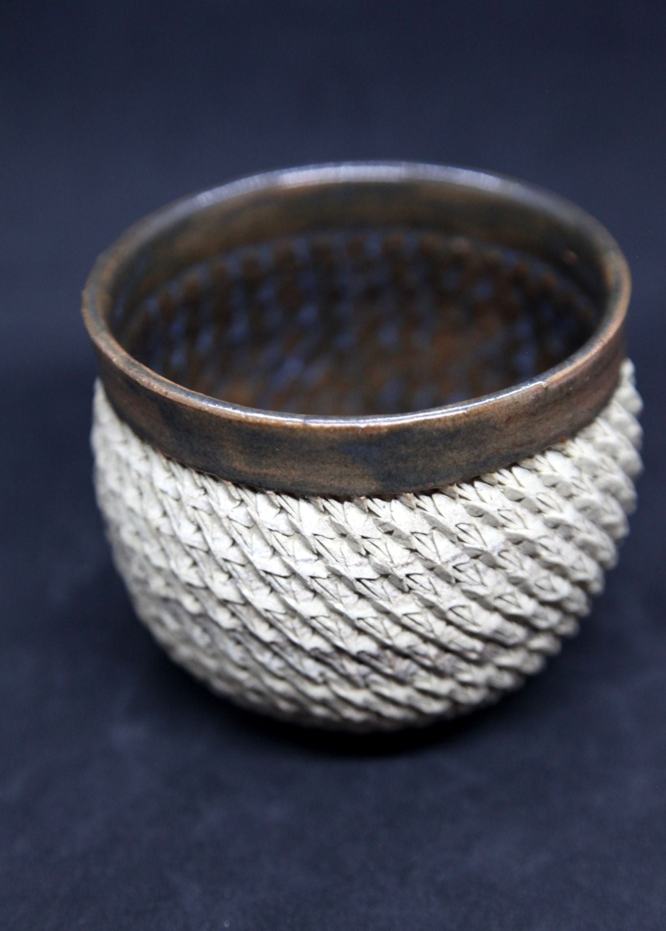 Brown and blue bowl on beige clay - braiding pattern
