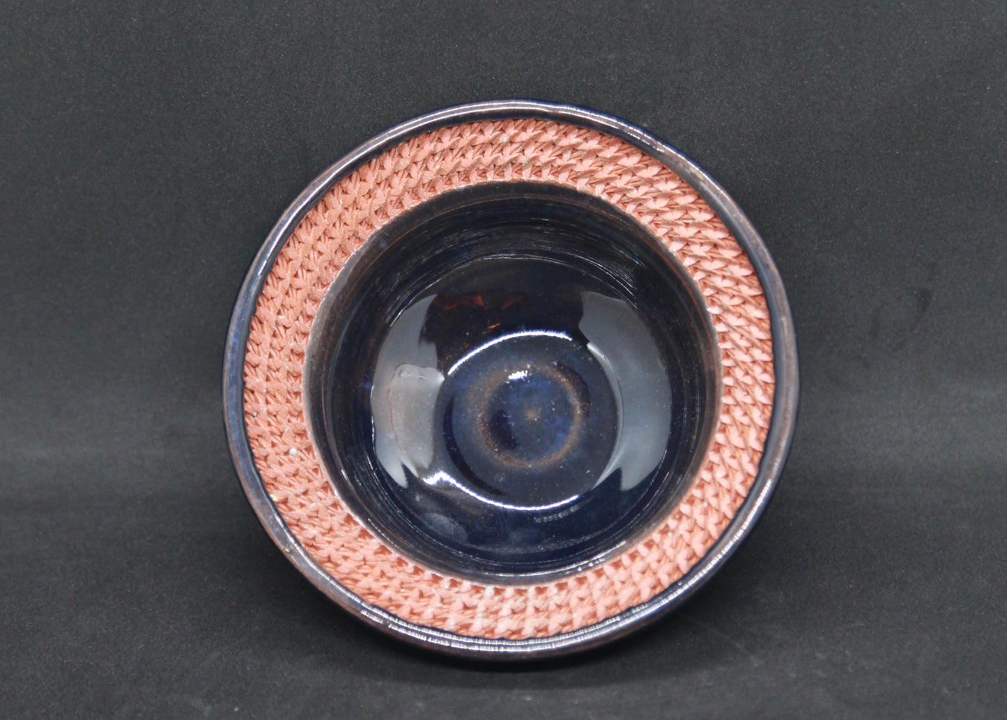 Dark blue marli bowl on red glaze - braiding pattern